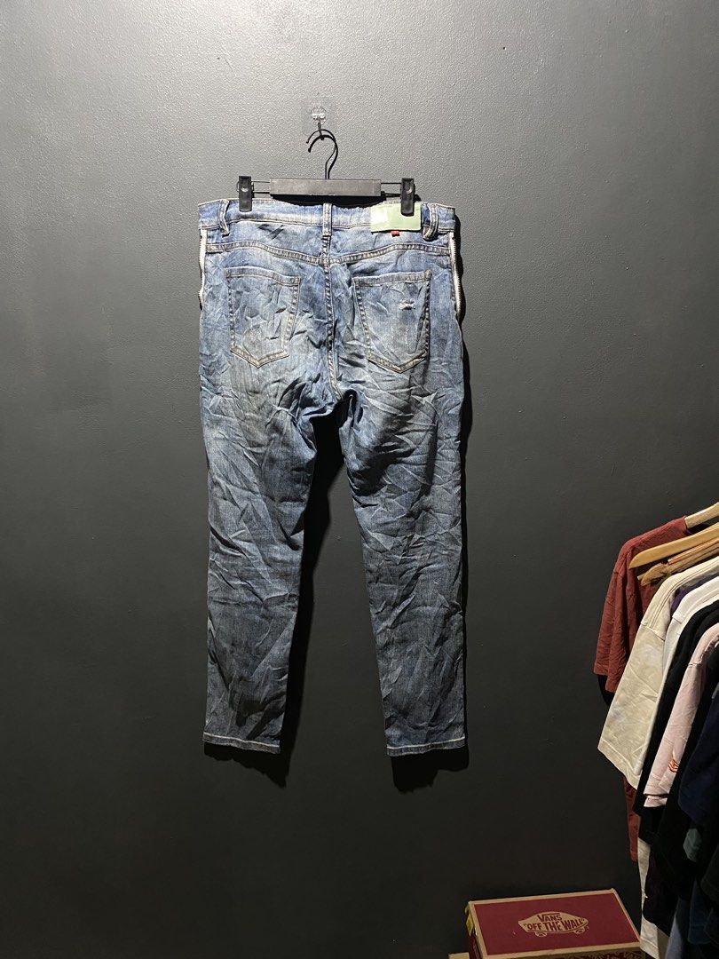 OFF-WHITE "DENIM LABEL" Distressed Zipper Jeans (Category: Jeans) located in Lucena. Submitted by handpickthrift (Listing ID 1453619084, Image 2). Description: - OFF-WHITE "DENIM LABEL" jeans - Classic blue wash with stylish distressed details size 32 - Functional zippers on the front - Signature ring zipper pulls with "OFF-WHITE C/O VIRGIL ABLOH" text - Unique and eye-catching design - Please check photos for detailed condition.