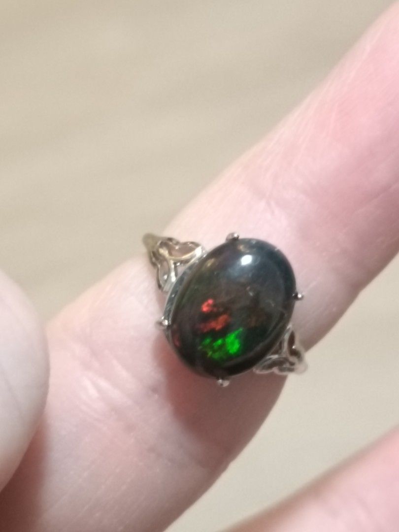 Opal ring (Category: Rings) located in Singapore. Submitted by subaru2.0 (Listing ID 1453522850, Image 1). Description: - Features a captivating black opal with striking red and green play-of-color. - Set in a beautifully detailed silver-plated band. - Elegant and unique design. - Perfect for adding a statement piece to your jewelry collection..