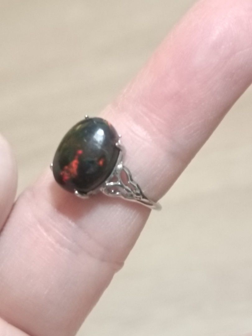 Opal ring (Category: Rings) located in Singapore. Submitted by subaru2.0 (Listing ID 1453522850, Image 2). Description: - Features a captivating black opal with striking red and green play-of-color. - Set in a beautifully detailed silver-plated band. - Elegant and unique design. - Perfect for adding a statement piece to your jewelry collection..