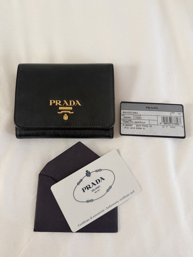 Prada Saffiano Leather Wallet Black (Category: Luxury Bags & Wallets) located in Butuan. Submitted by lovedbydy (Listing ID 1453473325, Image 1). Description: - Authentic Prada wallet - Black Saffiano leather - Gold Prada logo on front - Red interior card slots - Coin compartment - Includes authenticity card and envelope - Perfect for organizing cards and cash.