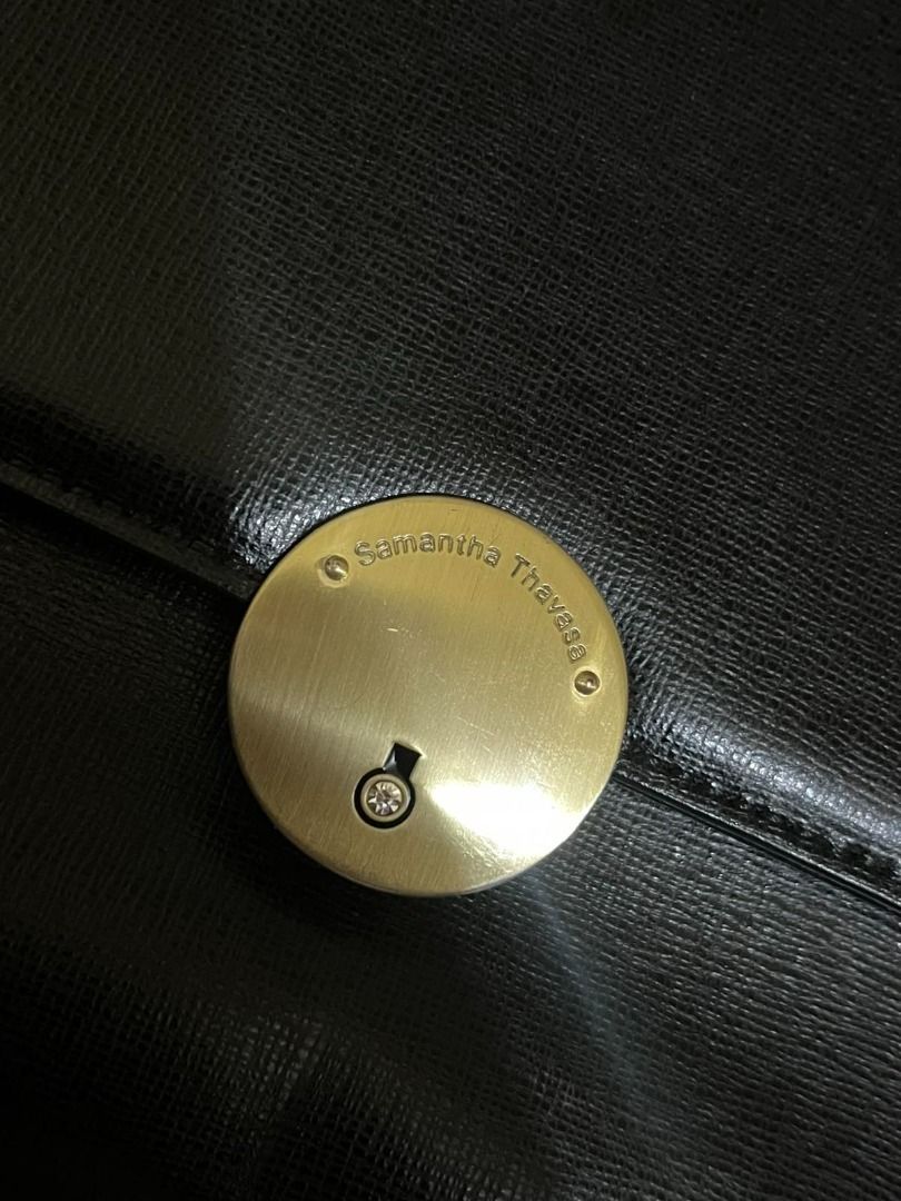 Samantha Thavasa Black Leather Top Handle Bag (Category: Luxury Bags & Wallets) located in Manila. Submitted by mela020 (Listing ID 1453601998, Image 2). Description: - Brand: Samantha Thavasa - Material: Black Leather - Design: Structured top handle bag - Hardware: Circular gold-tone clasp with gem detail - Interior: Clean - Occasion: Ideal for daily use or special events.