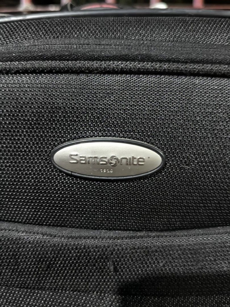 Samsonite Duralite Softside Spinner Trolley Bag (Category: Luggage) located in Calamba. Submitted by princesspauliney. (Listing ID 1453557595, Image 2). Description: Material: Built from a highly durable, lightweight structured nylon fabric designed to withstand heavy travel wear. Exterior Layout: Features a quick-access front zipper pocket, a sleek integrated Samsonite logo badge, and red accent stitch highlights at the bottom corners. Handling: