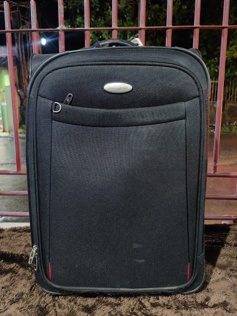 Samsonite Duralite Softside Spinner Trolley Bag (Category: Luggage) located in Calamba. Submitted by princesspauliney. (Listing ID 1453557595, Image 1). Description: Material: Built from a highly durable, lightweight structured nylon fabric designed to withstand heavy travel wear. Exterior Layout: Features a quick-access front zipper pocket, a sleek integrated Samsonite logo badge, and red accent stitch highlights at the bottom corners. Handling: