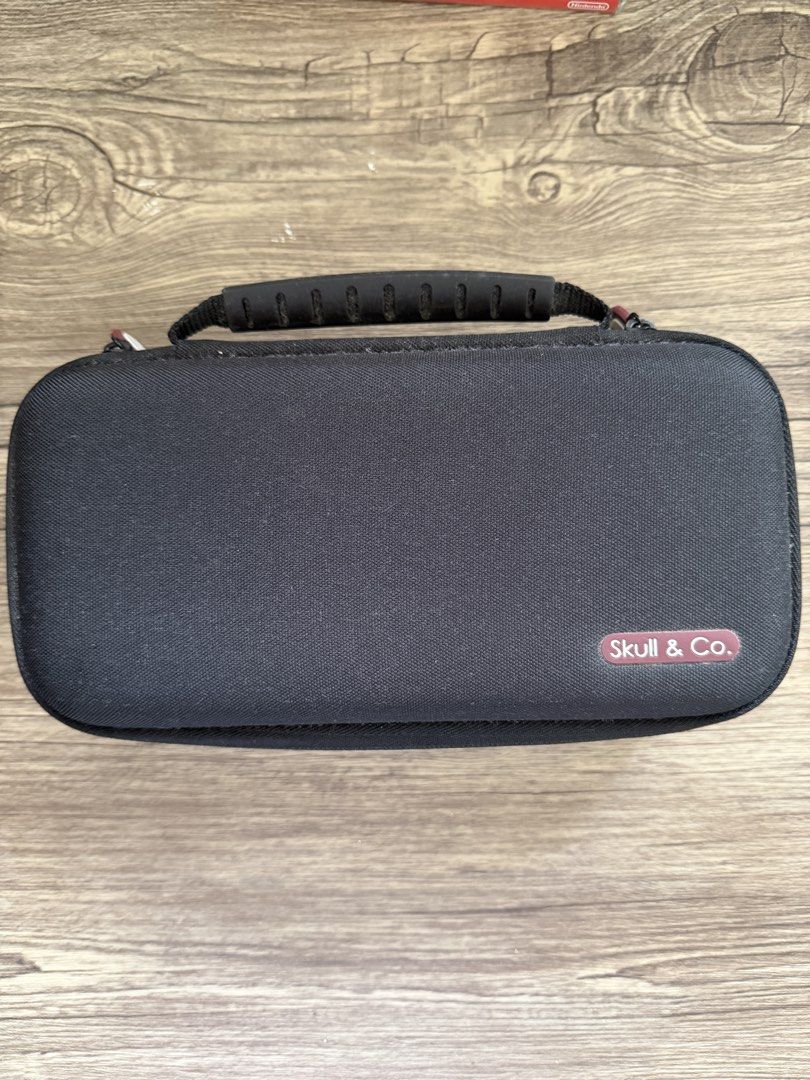 Skull & Co. Nintendo Switch Carrying Case (Category: Cases & Covers) located in Muntinlupa City. Submitted by theanicaela (Listing ID 1453618335, Image 1). Description: - Black carrying case for Nintendo Switch - Built-in handle for easy portability - Interior mesh pocket for accessories - Dedicated slots for game cartridges - Protects your console during travel.