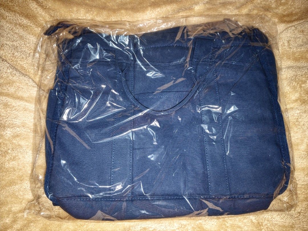 The EveryWear Tote Bag - Blue Canvas (Category: Tote Bags) located in Tanza. Submitted by declutterolshoppe (Listing ID 1453525890, Image 2). Description: - Brand new blue canvas tote bag - Still in original packaging - Features 'The EveryWear Tote' tag - Multiple exterior pockets for easy access - Ideal size for everyday essentials.