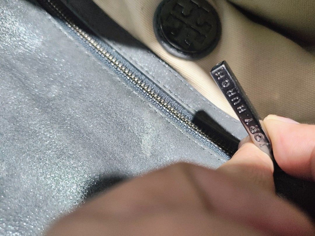 Tory Burch Grey Leather Chain Shoulder Bag (Category: Luxury Bags & Wallets) located in Taytay. Submitted by jhovie0202 (Listing ID 1453575368, Image 3). Description: - Grey Tory Burch leather shoulder bag - Features a stylish chain strap - Interior zippered pocket for essentials - Signature Tory Burch logo on the exterior - Shows some signs of wear on the leather - Ideal for casual outings and everyday use.