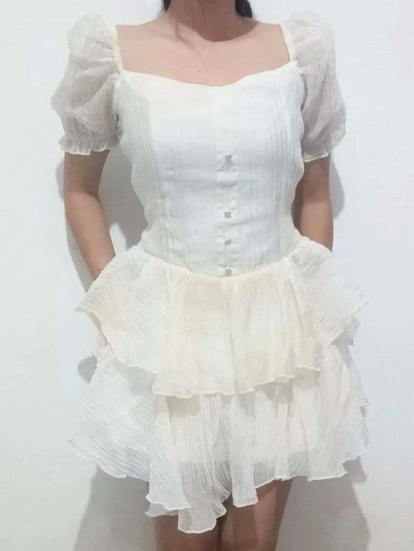 White Puff Sleeve Tiered Ruffle Dress (Category: Dresses) located in Quezon City. Submitted by alluring.avenue (Listing ID 1453482088, Image 2). Description: - Adorable white dress with charming puff sleeves. - Features a flattering square neckline and functional button details down the front. - Flowy skirt with stylish tiered ruffles. - Versatile for parties or everyday casual outings. - Effortless to style for any occasion..