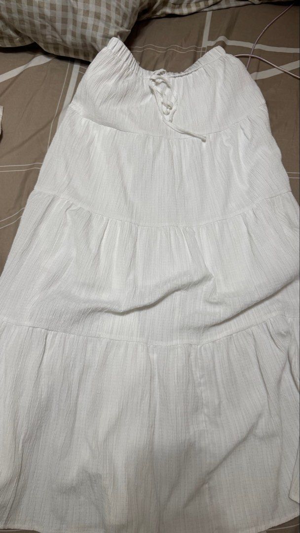 White Tiered Maxi Skirt with Drawstring Waist (Category: Skirts) located in San Pedro. Submitted by abbbnnn (Listing ID 1453507505, Image 1). Description: - White tiered maxi skirt - Textured fabric for a unique look - Comfortable elasticated waistband with adjustable drawstring tie - Estimated size S - Versatile for casual outings or dressing up.