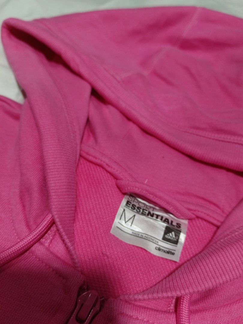 Adidas hoodie (Category: Coats, Jackets and Outerwear) located in Mendez-Nunez. Submitted by clarisucks (Listing ID 1458620560, Image 3). Description: The item in the image is a women's adidas hot pink full-zip hoodie. It features the brand's classic sporty elements, including drawstring adjustments at the hood, comfortable ribbed cuffs and hem, and iconic vertical 3-Stripes running down the sides. 17x22.