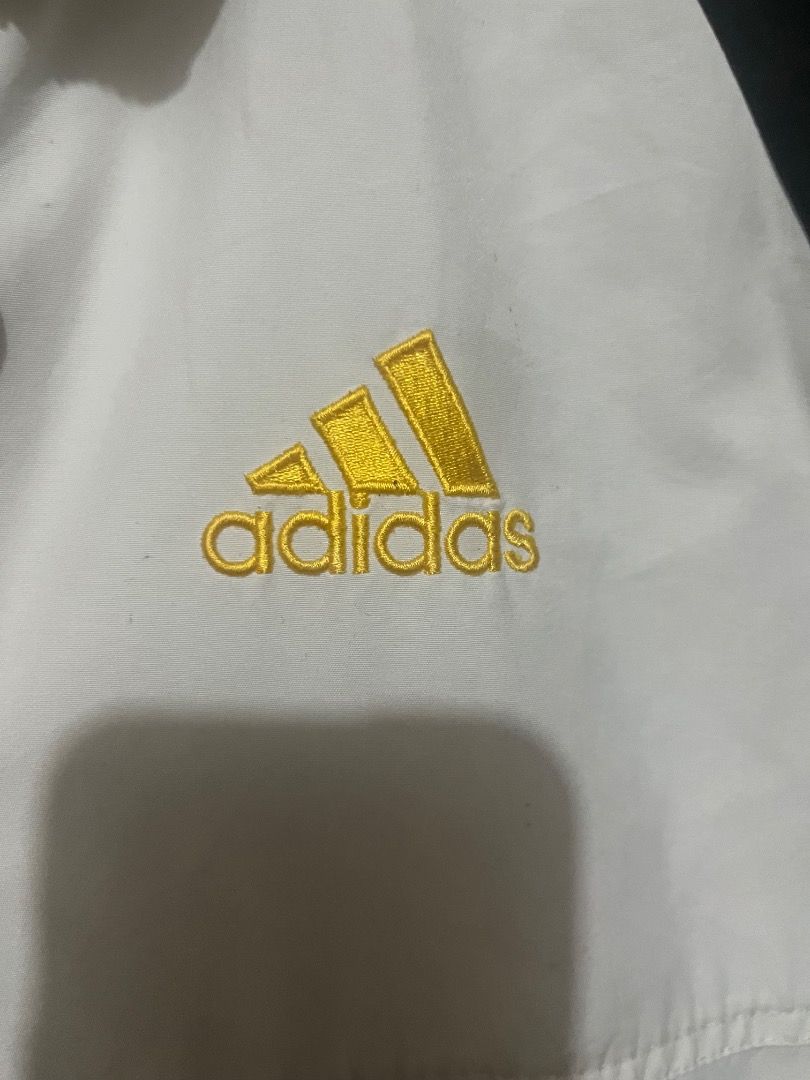 Adidas Track Jacket Black White Yellow Logo (Category: Coats, Jackets and Outerwear) located in Caloocan City. Submitted by riyenrie (Listing ID 1458537914, Image 3). Description: - Classic Adidas track jacket - Black sleeves and collar - White body with yellow Adidas logo on chest - Large Adidas logo graphic on back with yellow and teal accents - Ribbed cuffs and hem with yellow and black stripes - Zip-up front - Perfect for casual wear or sport