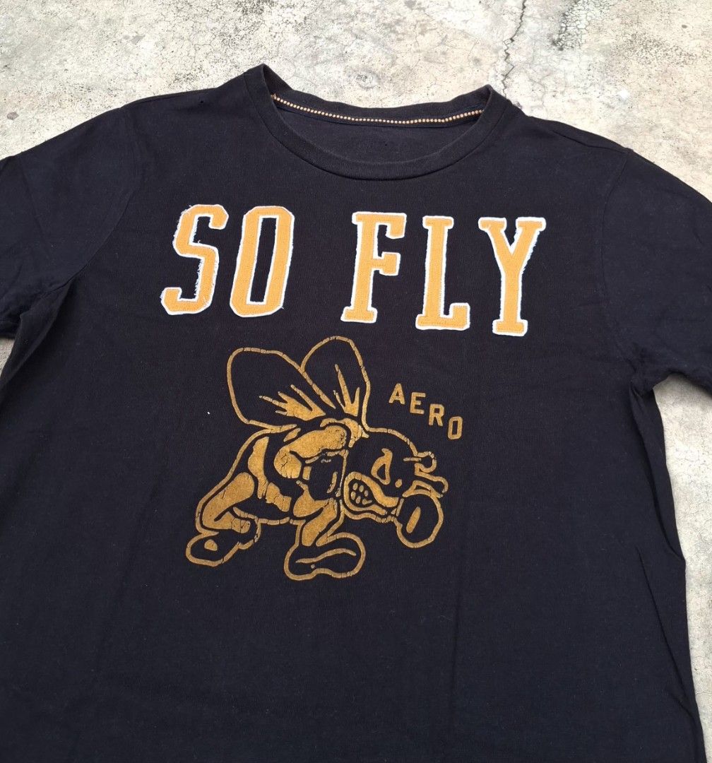 AERO "SO FLY" Bee Graphic T-Shirt (Category: Tshirts & Polo Shirts ) located in Iriga City. Submitted by _the_thrift_store_01 (Listing ID 1458574012, Image 2). Description: - Stylish black t-shirt - Features a "SO FLY" graphic with a bee wearing sunglasses - "AERO" text also included in the graphic - Classic crew neck and short sleeves - Ideal for casual everyday wear.