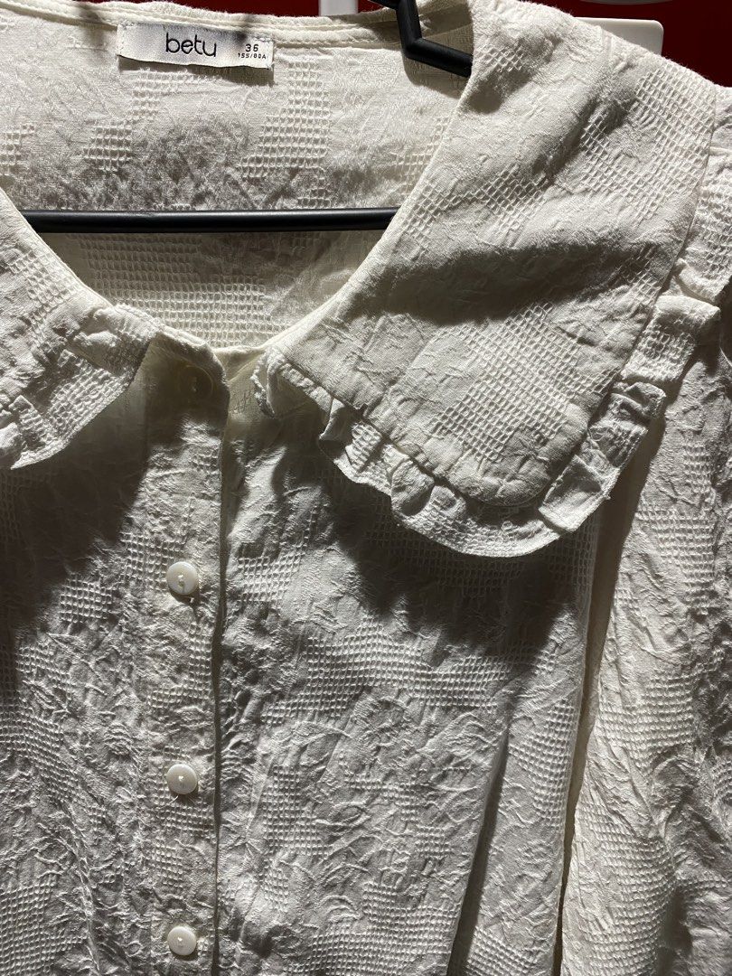 Betu White Textured Peter Pan Collar Blouse (Category: Blouses) located in Bauang. Submitted by nrrandomthings (Listing ID 1458660288, Image 2). Description: - White Betu blouse - Textured fabric all over - Cute Peter Pan collar with ruffled edges - Button-up front - Three-quarter sleeves - Pairs well with skirts or trousers.
