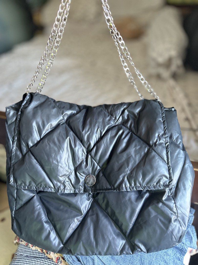 Black Puffer Shoulder Bag with Silver Chain Strap (Category: Shoulder Bags) located in Mandaluyong City. Submitted by TheWeekendProject (Listing ID 1458588363, Image 1). Description: - Lightweight Stylish black puffer bag - Elegant diamond quilt pattern - Chic silver chain strap - Secure button closure on front flap - Spacious interior for essentials - Ideal for casual outings.