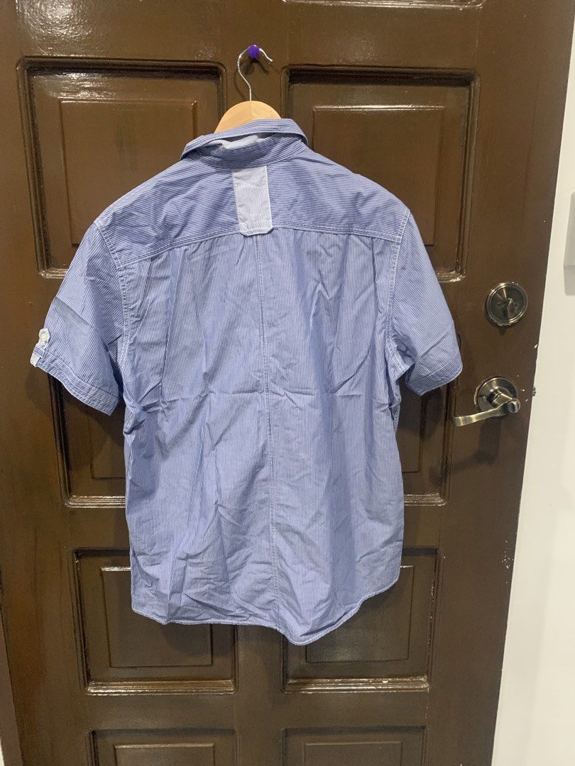 Blue Striped Short Sleeve Button Up Shirt (Category: Shirts) located in Paranaque City. Submitted by rizatamayo (Listing ID 1458527014, Image 2). Description: - Classic blue and white pinstripe short sleeve shirt - Features two chest pockets with button closures - Full button-up front - Measurements: Pit to pit approx. 21 inches, Length approx. 29 inches - Perfect for casual outings and everyday wear.