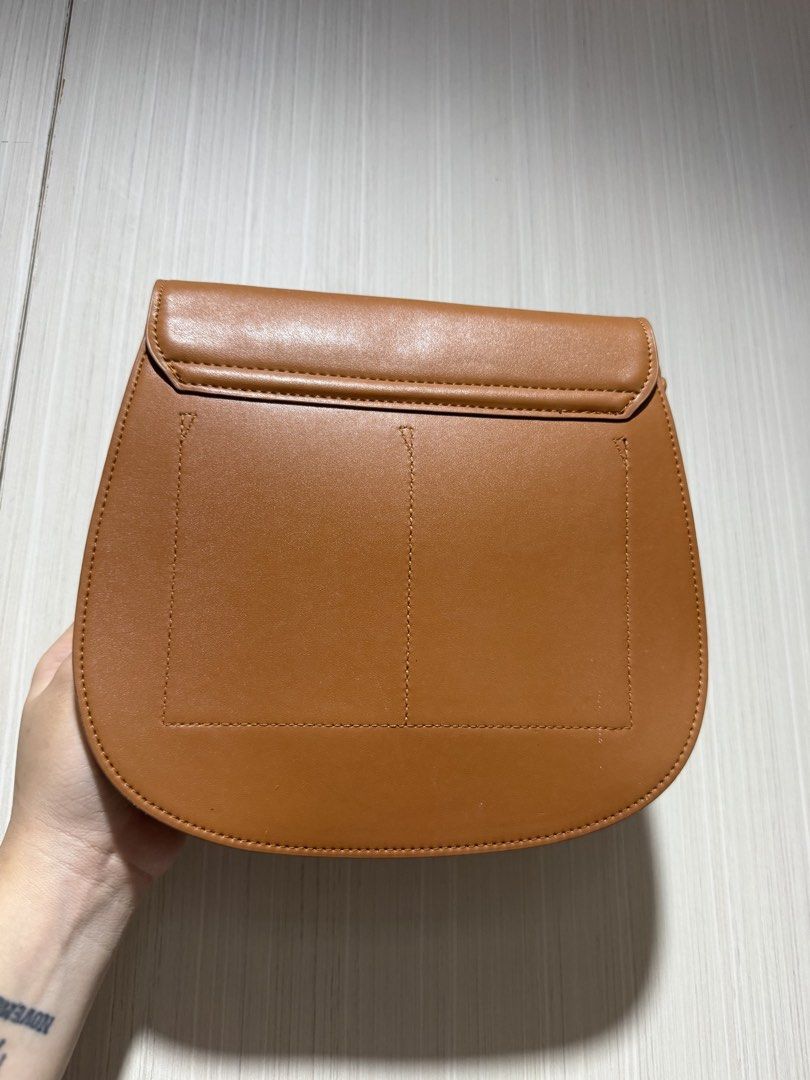 Brown Saddle Bag with Gold Clasp (Category: Luxury Bags & Wallets) located in Bacoor. Submitted by nicafindssince2022 (Listing ID 1458689368, Image 3). Description: - Cute brown saddle bag - Gold clasp closure - Faux leather material - Neat stitching - Minor signs of wear on flap edges (as pictured) - Ideal size for everyday essentials - Great for casual outings - With minimal signs of use.
