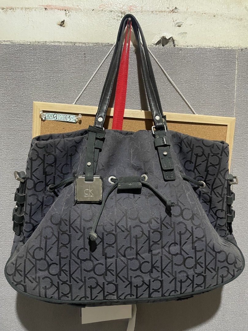 Calvin Klein CK Monogram Tote Bag (Category: Luxury Bags & Wallets) located in Manila. Submitted by beabohol0249530 (Listing ID 1458613174, Image 1). Description: - Classic Calvin Klein tote bag - All-over CK monogram print - Black and grey colorway - Genuine leather straps and details - Secure drawstring closure with metal hardware - Spacious interior for all your essentials - Ideal everyday bag.