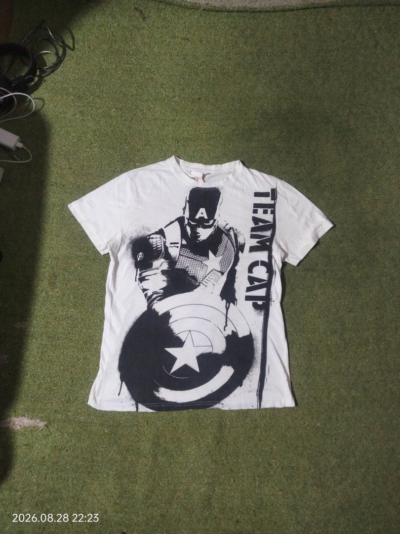 Civil War Captain America "Team Cap" (Category: Tshirts & Polo Shirts ) located in Caloocan City. Submitted by haruconcep52476 (Listing ID 1458661157, Image 1). Description: Captain America Marvel Comics Dimensions W19×L27 Good condition Color rate 9 Issue need wash and loose stitch on tag - White t-shirt featuring a cool Captain America graphic. - "Team Cap" text on the side. - Ideal for any Marvel fan. - Great for everyday casual wear. - Refer 