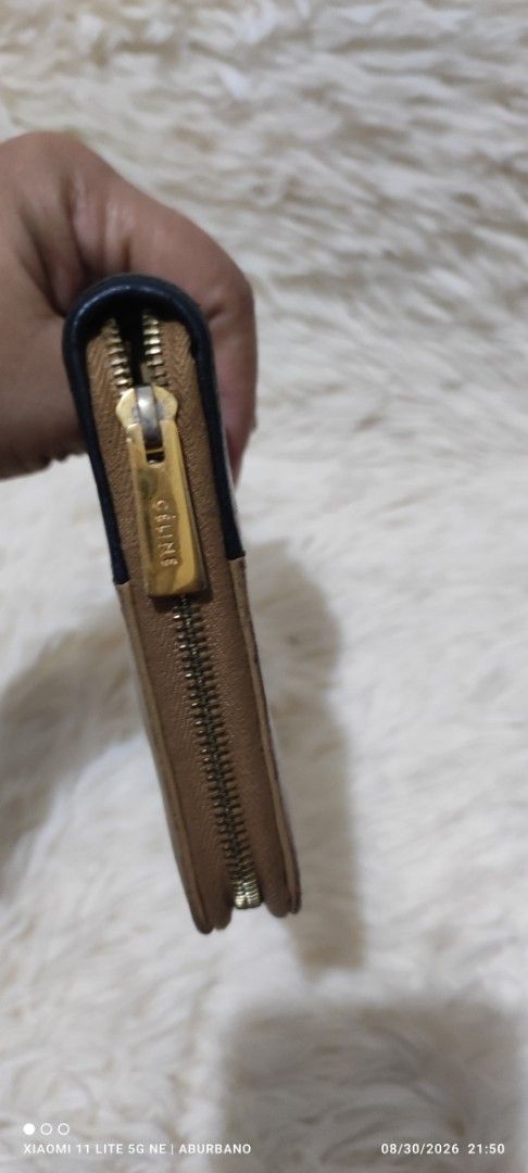 CÉLINE Bi-color Wallet (Category: Luxury Bags & Wallets) located in Makati City. Submitted by yerbua103 (Listing ID 1458642973, Image 3). Description: Celine bi-color leather zip-around long wallet in dark beige and black. Interior is leather and has a wide zip compartment, card slots and bills. Manage your expectations as you're buying a preloved wallet. .