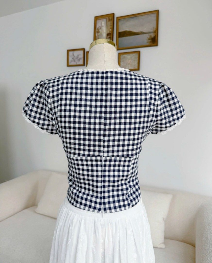 Clothes Bar Niori Gingham Top (Category: Blouses) located in Cavite. Submitted by jaimee_go (Listing ID 1458569947, Image 3). Description: The Niori Top – Navy Gingham is a cute and feminine top with a classic navy and white check pattern. With tiny lace details and a sweet bow, this top gives you a youthful and neat look that goes perfectly with high-waisted skirts or pants. Main Fabric: High-quality Linen with a classic navy and white gingham p