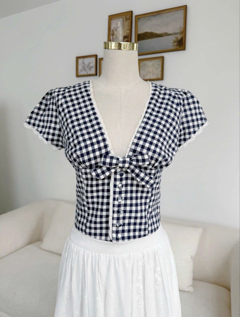 Clothes Bar Niori Gingham Top (Category: Blouses) located in Cavite. Submitted by jaimee_go (Listing ID 1458569947, Image 1). Description: The Niori Top – Navy Gingham is a cute and feminine top with a classic navy and white check pattern. With tiny lace details and a sweet bow, this top gives you a youthful and neat look that goes perfectly with high-waisted skirts or pants. Main Fabric: High-quality Linen with a classic navy and white gingham p
