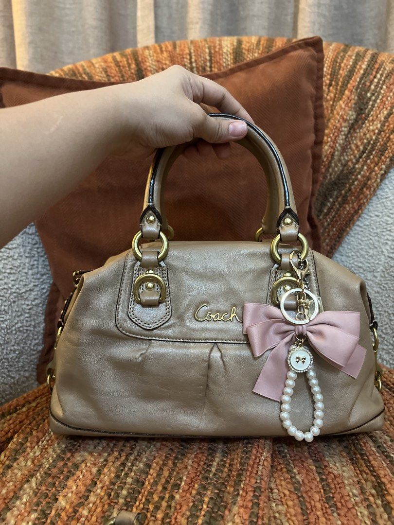 Coach ashley satchel bag (Category: Luxury Bags & Wallets) located in Bulacan. Submitted by dandan2131 (Listing ID 1458621537, Image 1). Description: This appears to be a metallic Coach Ashley leather satchel featuring a pleated front accented with a pink bow and pearl charm..