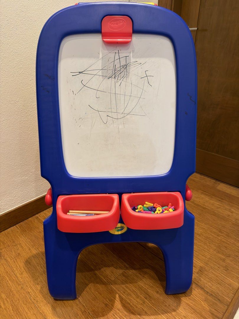Crayola Double-Sided Easel with Trays (Category: Stationery & School Supplies) located in Taguig. Submitted by patricia_preloved (Listing ID 1458600479, Image 2). Description: - Yellow and blue Crayola easel - Double-sided: Green chalkboard on one side, whiteboard on the other - Two convenient storage trays at the bottom - Perfect for kids' art and creative projects - Includes magnetic letters and a marker - Note: Whiteboard has some minor scribb