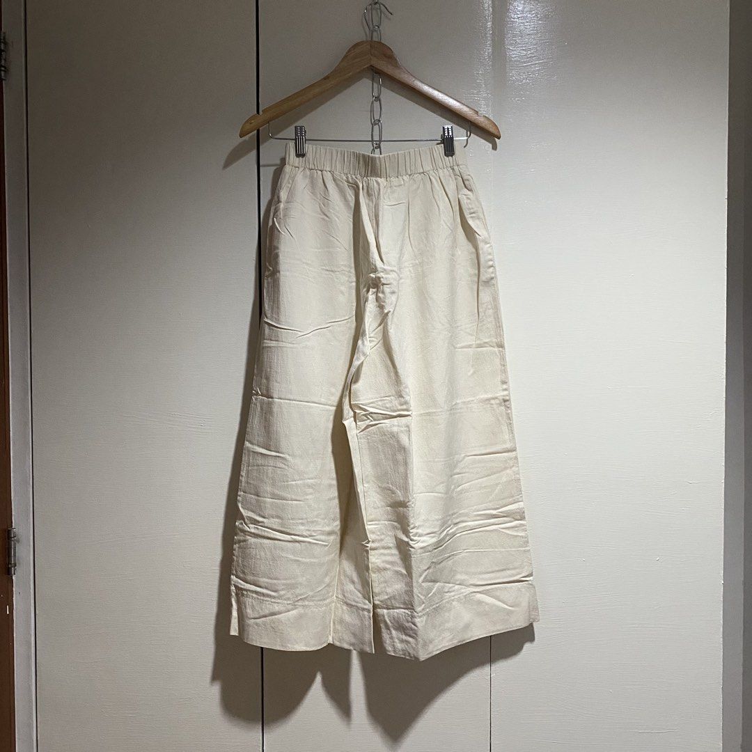Cream Wide Leg Pants (Category: Other Bottoms) located in Cavite. Submitted by branchee_chic (Listing ID 1458573555, Image 2). Description: W: 24-28 L: 34 Linen fabric - Cream colored wide leg pants - High-waisted with front pleats - Elastic waistband at the back for comfort - Cropped length - Versatile for casual or dressed-up looks.
