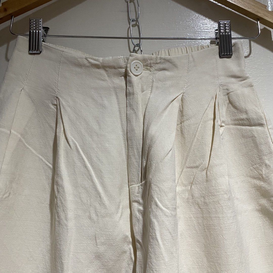 Cream Wide Leg Pants (Category: Other Bottoms) located in Cavite. Submitted by branchee_chic (Listing ID 1458573555, Image 3). Description: W: 24-28 L: 34 Linen fabric - Cream colored wide leg pants - High-waisted with front pleats - Elastic waistband at the back for comfort - Cropped length - Versatile for casual or dressed-up looks.