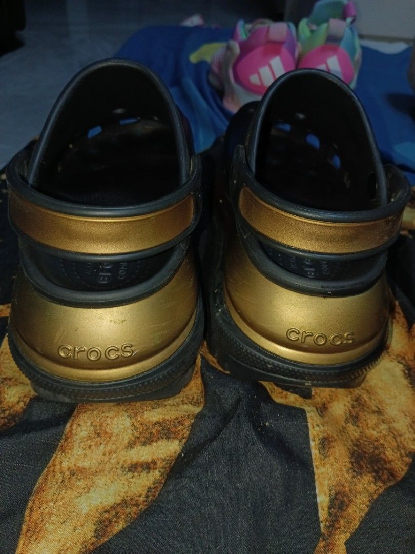 Crocs Platform Clogs Black Gold Women's Size (Category: Slippers and slides) located in Caloocan City. Submitted by kurtelle1825721 (Listing ID 1458599265, Image 2). Description: - Classic black Crocs - Features a stylish gold platform - Iconic Crocs branding on heel strap - Easy slip-on design - Versatile for casual wear or making a statement.