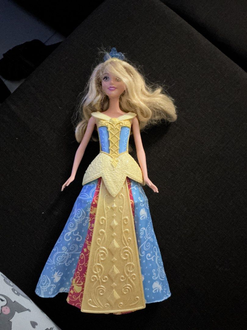 Disney Princess Aurora Doll (Category: Kids Toys) located in San Fernando. Submitted by takkou (Listing ID 1458614642, Image 1). Description: - Authentic Disney Aurora doll - Signature blonde hair - Beautiful blue and pink gown - Yellow bodice with a patterned skirt - Ready for imaginative play - Ideal gift for any Disney enthusiast.