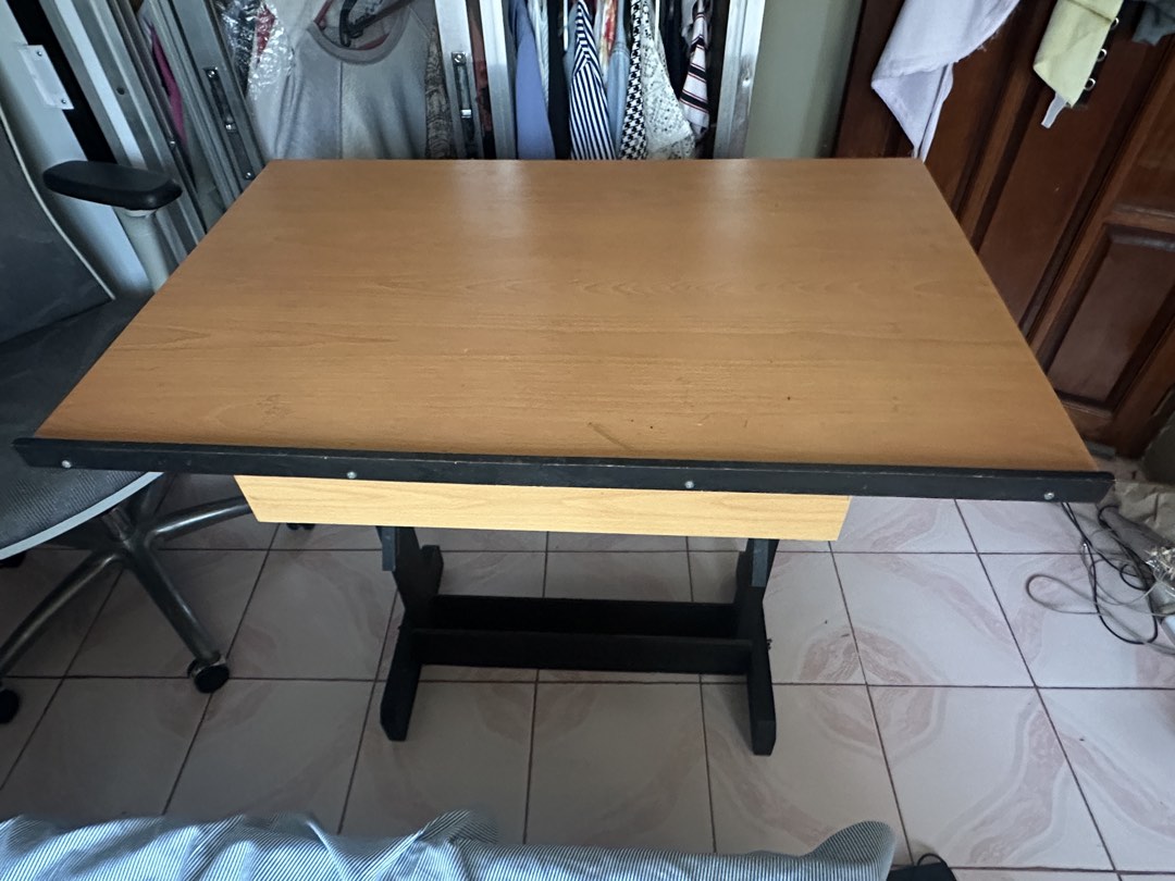 Drafting Table (Category: Tables & Sets) located in Imus. Submitted by bleakblob (Listing ID 1458674354, Image 3). Description: - Adjustable wooden drawing table with customizable height and angle. - Features a smooth, ready-to-use surface for all your creative projects. - Light ink marks are visible on the surface but the surface is still smooth and ideal for drafting..
