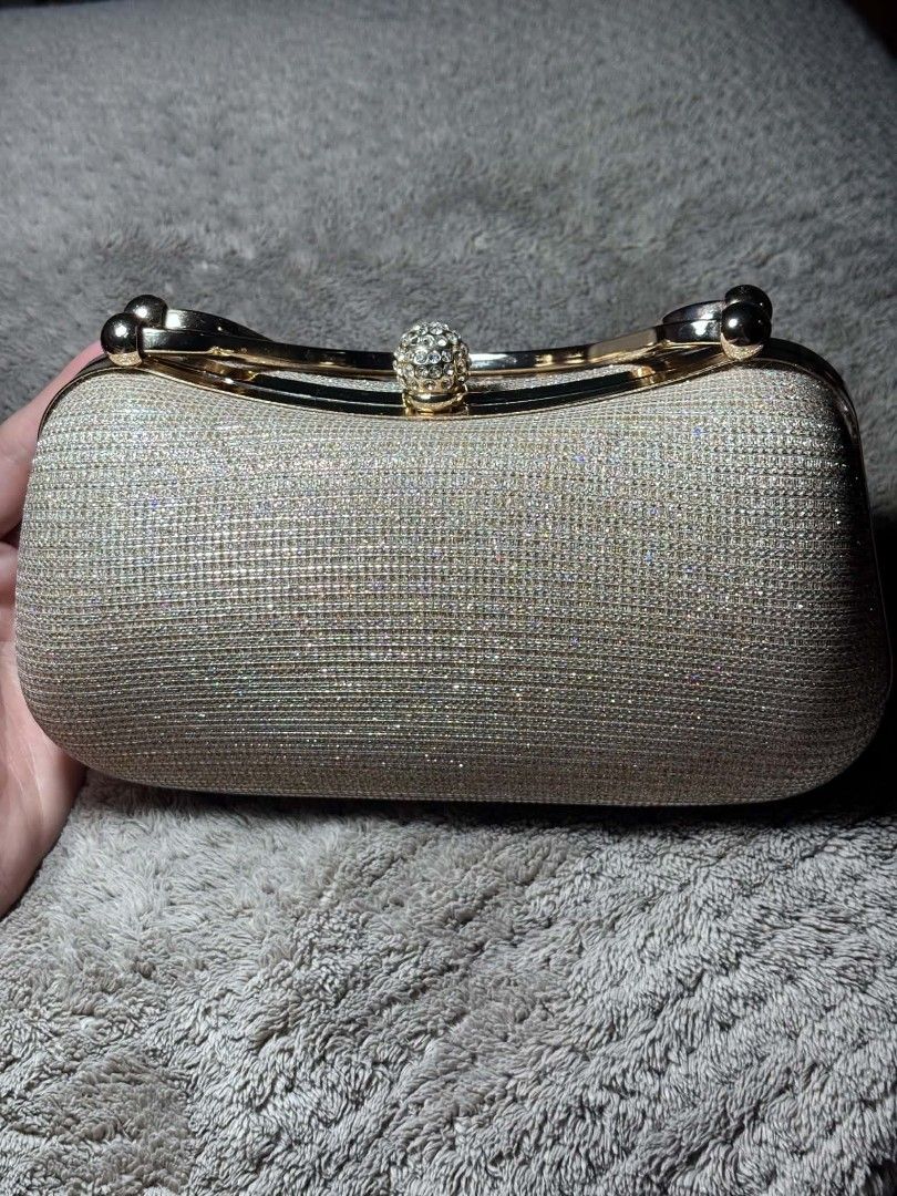 Evening Clutch Bag (Category: Clutches) located in Manila. Submitted by jane_015 (Listing ID 1458668433, Image 1). Description: - Stunning sparkly gold clutch - Elegant rhinestone ball clasp - Lined with black fabric interior - Includes a delicate gold chain - Ideal for parties, weddings, and special events - A true eye-catcher! 📌 Color: Light Gold 📌 Price: ₱300 Location: Antipolo 🚚 Shipping available — buyer shoulders shipping fee 🛵 Same-day