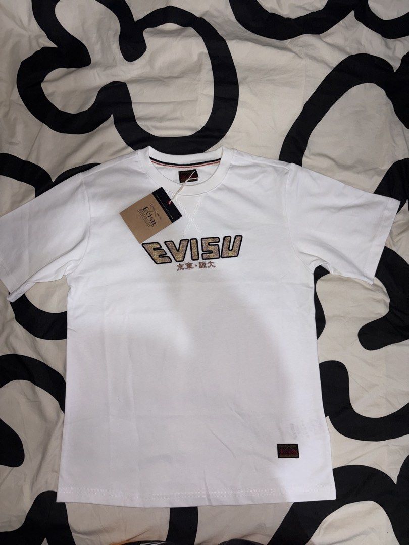 EVISU White T-Shirt with Graphic Print (Category: Tshirts & Polo Shirts ) located in Makati City. Submitted by sanron12156139 (Listing ID 1458526526, Image 2). Description: - Authentic White Evisu T-shirt - Features a cool graphic design on the back - Evisu logo prominently displayed on the front - Ideal for everyday casual wear.