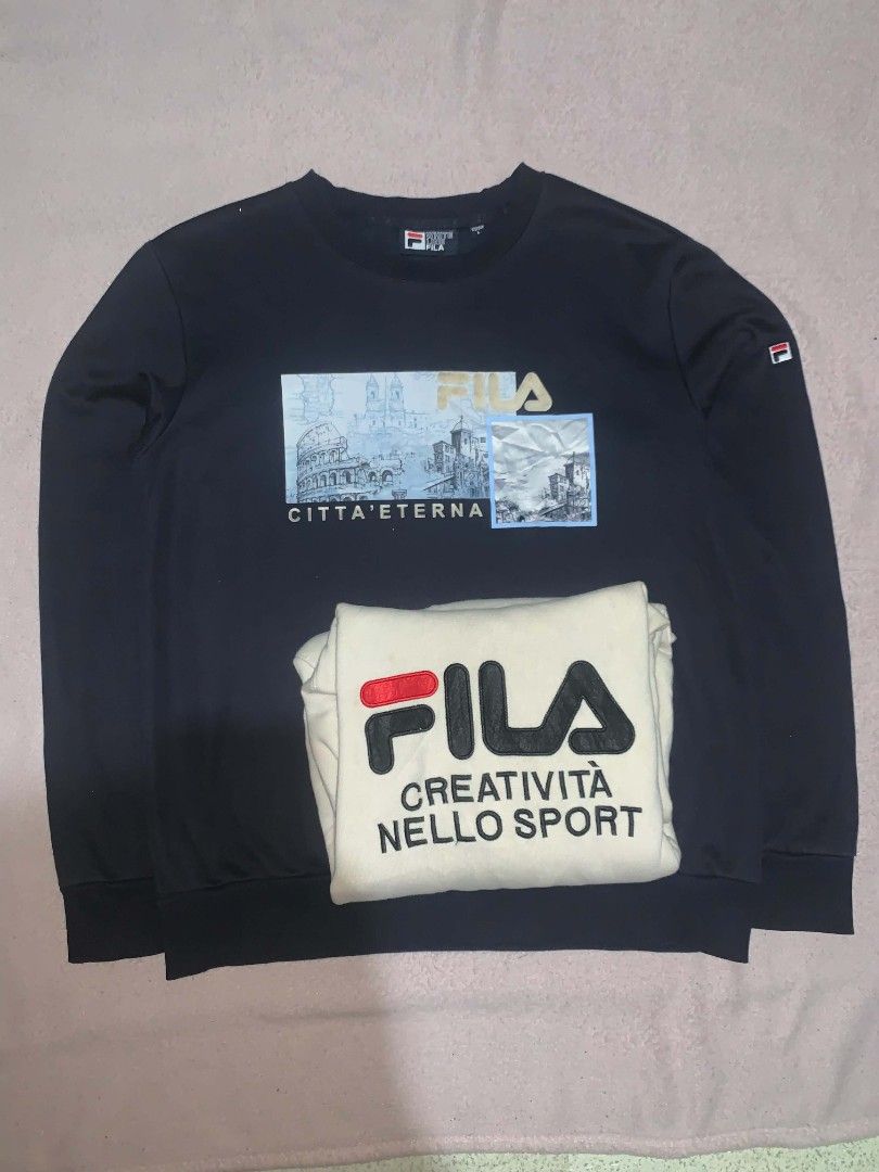 Fila Hoodie and Sweatshirt Bundle (Category: Coats, Jackets and Outerwear) located in Manila. Submitted by ukayd_vntg_thrft_2.0 (Listing ID 1458678668, Image 2). Description: - Fila Cream Hoodie: Features iconic Fila logo and Italian text. Comfortable and stylish for everyday wear. - Fila Black Sweatshirt: Showcases a unique graphic print of Roman landmarks with Italian text. Perfect for a stylish casual look. - Both items are designed for ultima