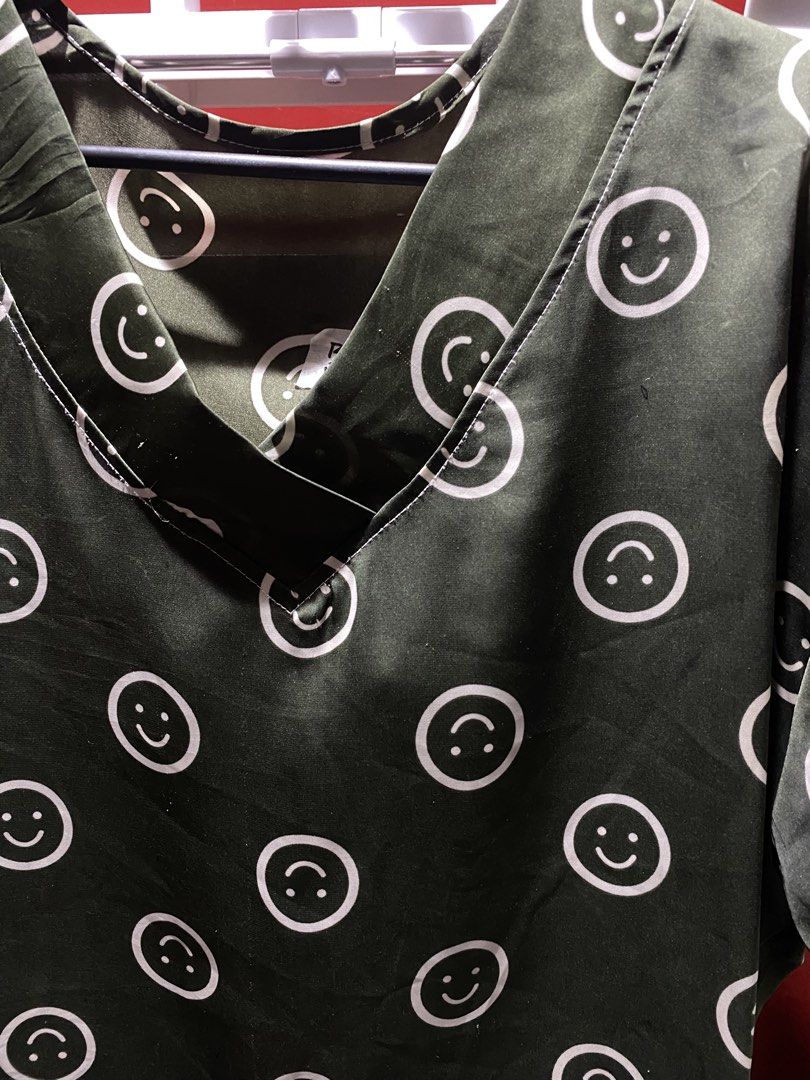 Green Smiley Face V-Neck Top (Category: Shirts) located in Bauang. Submitted by nrrandomthings (Listing ID 1458659717, Image 2). Description: - Adorable green V-neck top - Features a repeating smiley face pattern - Short sleeves for a comfortable fit - Fabric has a subtle sheen - Ideal for casual outfits - Pairs well with jeans or shorts.