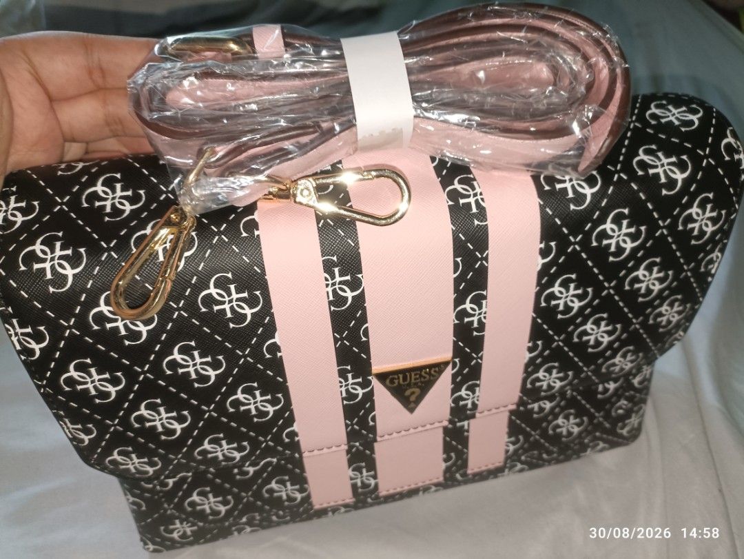 Guess Monogram Clutch Bag with Pink Stripes (Category: Clutches) located in Caloocan City. Submitted by calm.gentle.carleenballes (Listing ID 1458560296, Image 2). Description: - Guess clutch bag with signature monogram print - Features pink stripe details - Gold Guess logo accent - Interior with multiple compartments - Includes a detachable strap - Ideal for evenings out or as a statement piece.