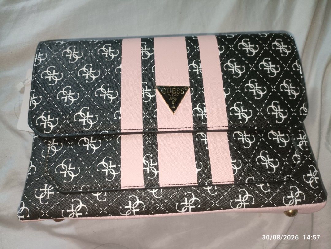 Guess Monogram Clutch Bag with Pink Stripes (Category: Clutches) located in Caloocan City. Submitted by calm.gentle.carleenballes (Listing ID 1458560296, Image 3). Description: - Guess clutch bag with signature monogram print - Features pink stripe details - Gold Guess logo accent - Interior with multiple compartments - Includes a detachable strap - Ideal for evenings out or as a statement piece.