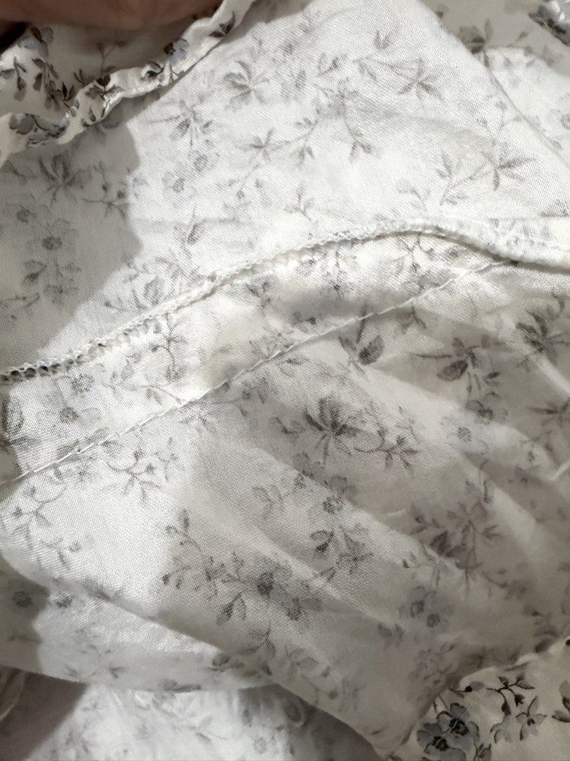 H&M Floral Ruffle Button Up Blouse Size M (Category: Blouses) located in Imus. Submitted by gclmom (Listing ID 1458617540, Image 3). Description: - Delicate white blouse with a charming blue floral print. - Elegant ruffled neckline adds a feminine touch. - Classic button-up front for easy wear. - Three-quarter sleeves with stylish ruffled cuffs. - Made from lightweight fabric, ideal for staying cool. - Effortlessly dress it up or down for any out