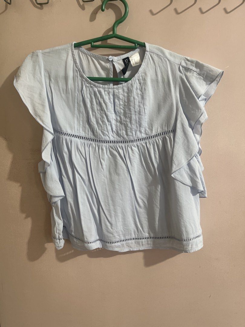 H&M Light Blue Ruffle Sleeve Blouse (Category: Blouses) located in Quezon City. Submitted by lune17 (Listing ID 1458545145, Image 1). Description: - can fit to medium - Light blue blouse from H&M Divided - Features cute ruffle sleeves - Pintuck details on the front - Keyhole opening at the back with button closure - Versatile for casual or slightly dressy outfits.