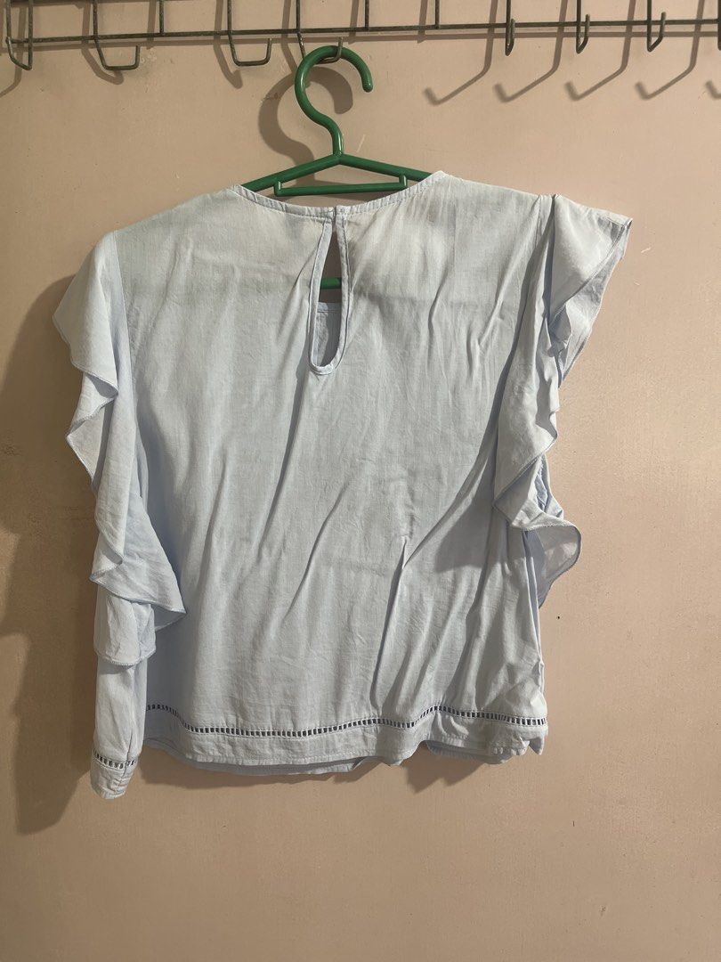 H&M Light Blue Ruffle Sleeve Blouse (Category: Blouses) located in Quezon City. Submitted by lune17 (Listing ID 1458545145, Image 2). Description: - can fit to medium - Light blue blouse from H&M Divided - Features cute ruffle sleeves - Pintuck details on the front - Keyhole opening at the back with button closure - Versatile for casual or slightly dressy outfits.