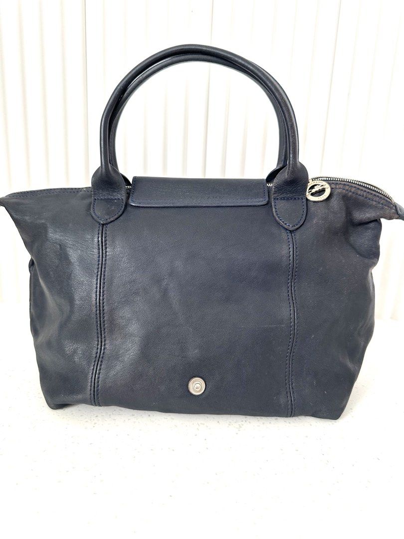 Longchamp Le Pliage Cuir Small Top Handle Bag Navy (Category: Luxury Bags & Wallets) located in Quezon City. Submitted by nancdmd (Listing ID 1458659676, Image 2). Description: - Navy blue Longchamp Le pliage cuir - Made of soft leather - Features top handles - Includes a detachable shoulder strap - Secure snap button flap closure - Ample interior space for essentials - Ideal for everyday use or travel.