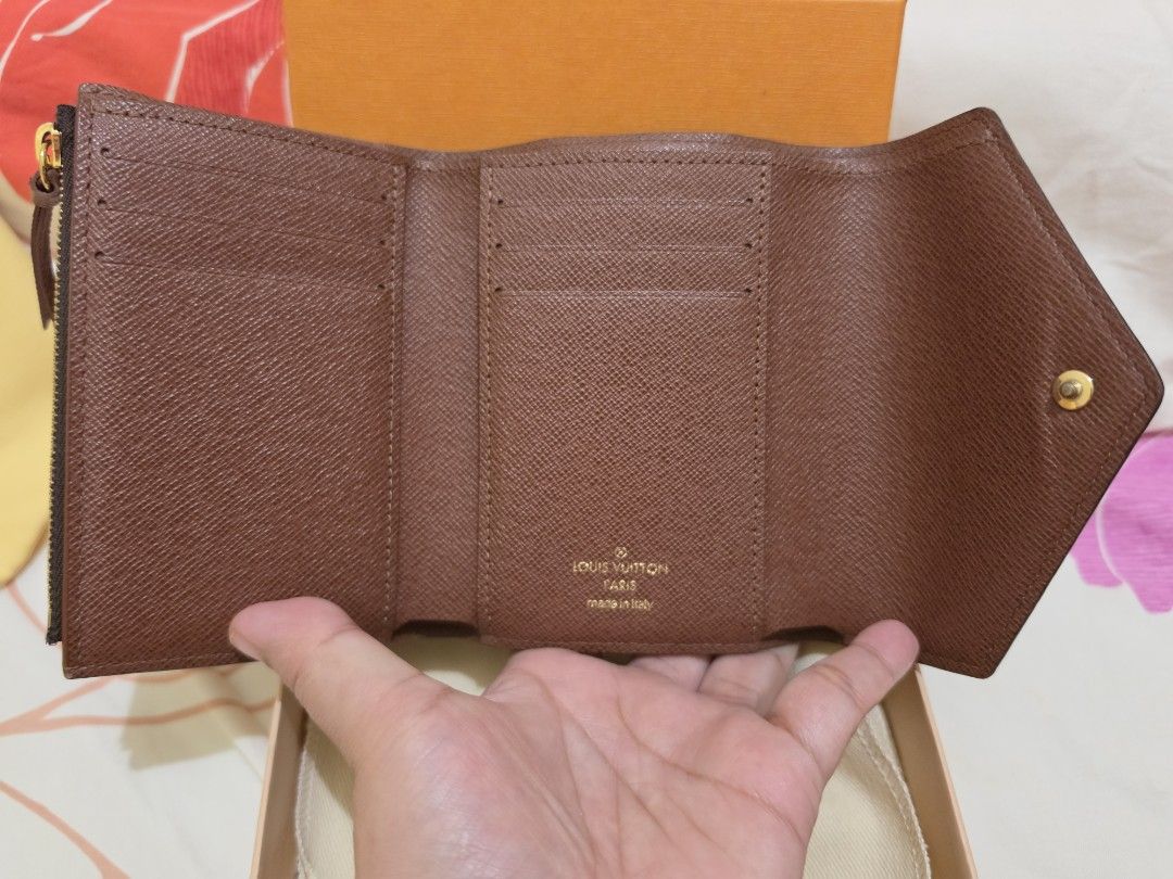 Louis Vuitton Victorine Monogram Tri-Fold Wallet (Category: Luxury Bags & Wallets) located in Cavite. Submitted by kazi_preloved (Listing ID 1458586297, Image 2). Description: - 100% Authentic Louis Vuitton wallet - Microchip already. - Classic Monogram canvas design - Secure snap button closure - Convenient zipped coin pocket - Multiple card slots and bill compartments for organization - Comes with original box, dust bag, and entrupy certificate