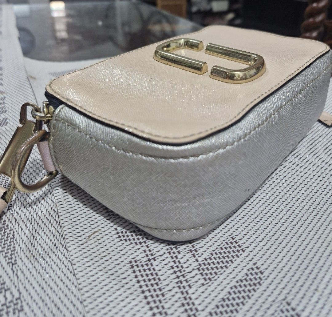 Marc Jacobs Snapshot Camera Bag - Beige/Silver (Category: Luxury Bags & Wallets) located in Las Pinas. Submitted by jmproperties (Listing ID 1458622332, Image 3). Description: - Authentic Marc Jacobs camera bag - Chic beige and silver colorway - Iconic gold double J logo hardware - Secure zipper closure - Adjustable strap for comfortable wear - Ideal for everyday essentials - Shows some signs of wear on hardware NO SLING STRAP included.