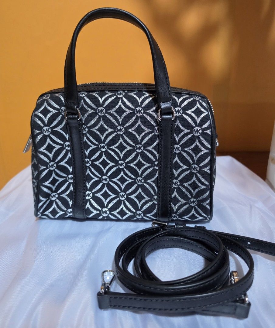 Michael Kors Monogram Mini Duffle Bag (Category: Luxury Bags & Wallets) located in Pasig City. Submitted by miamendoza30 (Listing ID 1458533314, Image 2). Description: - Authentic Michael Kors mini duffle bag - Classic black with signature silver MK monogram pattern - Versatile carrying options: top handles and detachable crossbody strap - Secure zipper closure to keep your belongings safe - Interior slip pocket for small essentials - Ideal size 