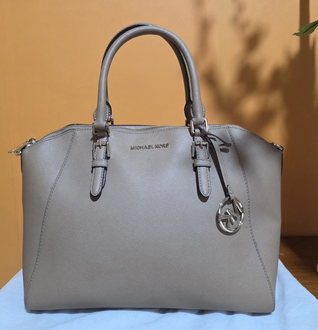 Michael Kors Tote Bag (Category: Luxury Bags & Wallets) located in Pasig City. Submitted by miamendoza30 (Listing ID 1458529438, Image 1). Description: - Authentic Michael Kors tote bag in a Khaki color. - Crafted from genuine leather for a luxurious feel. - Elegant gold-tone hardware details. - Secure zipper closure to keep your belongings safe. - Comfortable top handles for easy carrying. - Includes a stylish Michael Kors charm. - Perfect for d