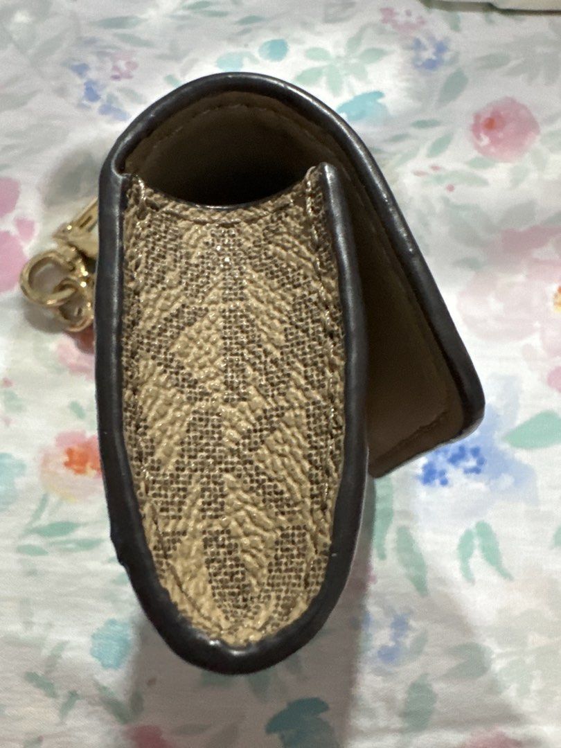 MK clip case (apple airpod) (Category: Headphones & Headsets) located in Pasay City. Submitted by docnanz67 (Listing ID 1458641742, Image 3). Description: This is a Michael Kors AirPods case featuring a beige leather flap with the signature gold-tone MK logo snap and monogram canvas.