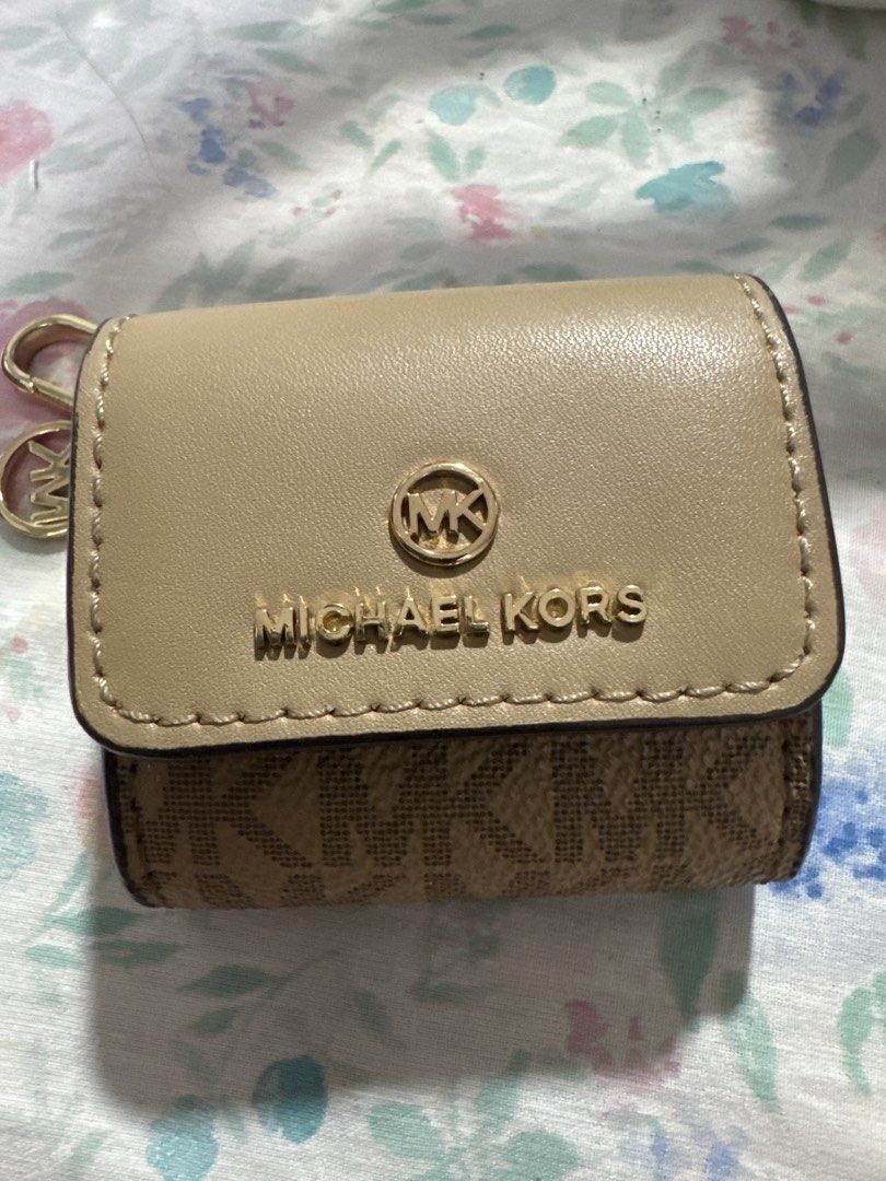 MK clip case (apple airpod) (Category: Headphones & Headsets) located in Pasay City. Submitted by docnanz67 (Listing ID 1458641742, Image 1). Description: This is a Michael Kors AirPods case featuring a beige leather flap with the signature gold-tone MK logo snap and monogram canvas.