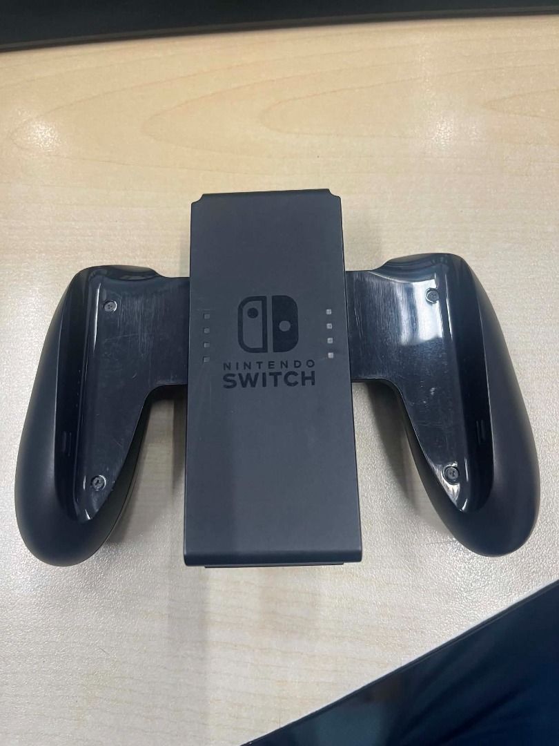 Nintendo Switch Joy-Con Charging Grip (Category: Controllers) located in Manila. Submitted by cdcalarcon82801 (Listing ID 1458524039, Image 1). Description: - Original Nintendo Switch Charging Grip - Play with Joy-Cons attached - Charges Joy-Cons while you play - Ideal for longer gaming sessions - Provides a better grip for enhanced gameplay - Compatible with Nintendo Switch.