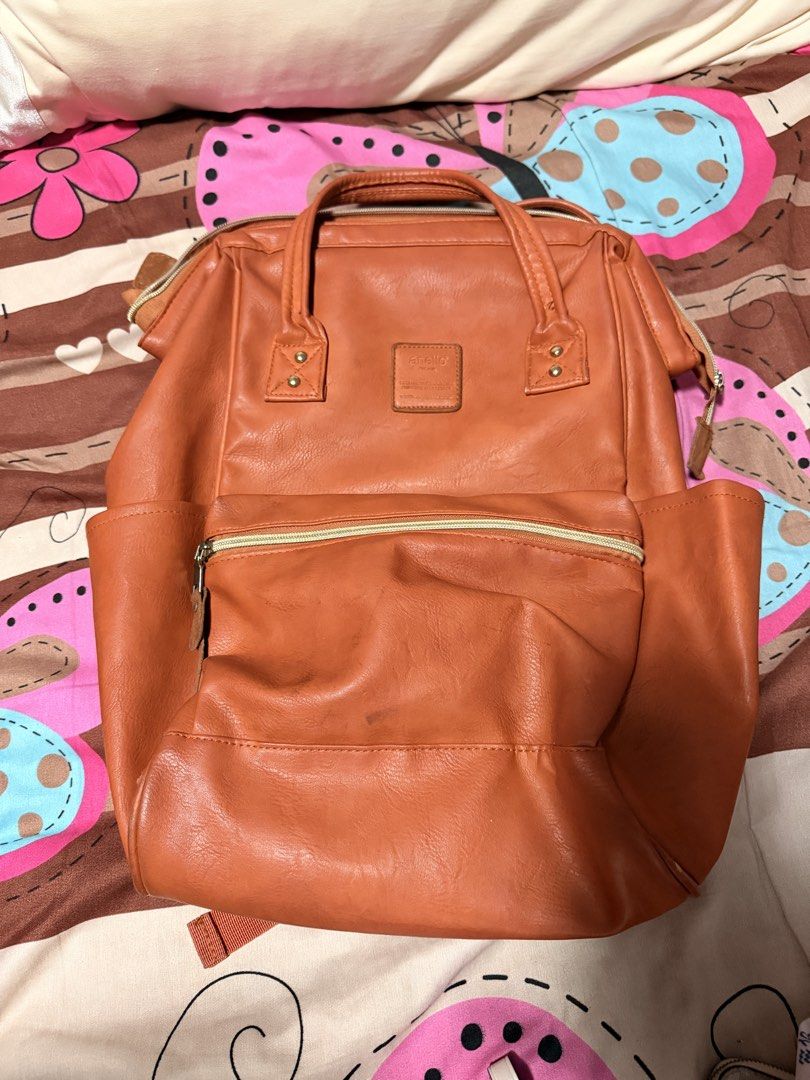 ORIGINAL Anello Brown Faux Leather Backpack (Category: Backpacks) located in Paranaque City. Submitted by keyas.preloved (Listing ID 1458579856, Image 1). Description: - Brown faux leather backpack - Main compartment with internal pockets - Front zippered pocket - Two side pockets - Adjustable straps - Exterior shows some scuffs and marks, particularly on the back but you can wash it for it to be removed - Interior is clean.