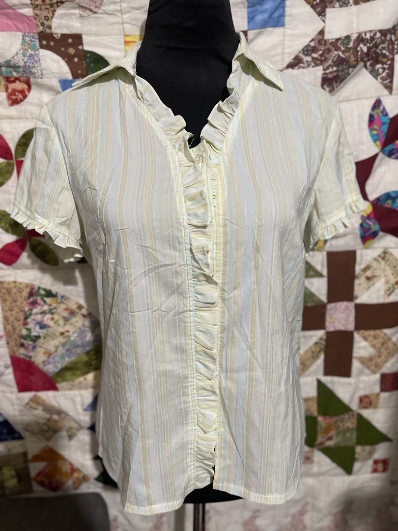 Pastel Vertical Stripe Ruffle Trim Button-Down Blouse (Size L) (Category: Blouses) located in Roxas City. Submitted by budgetfindsroxasph (Listing ID 1458574646, Image 2). Description: Add a sweet, vintage touch to your collection with this lightweight pastel striped short-sleeve blouse. Features soft yellow, light blue and neutral vertical stripes, an open-notch collar, dainty ruffle-trimmed sleeves, and a delicate ruffled front placket over hid